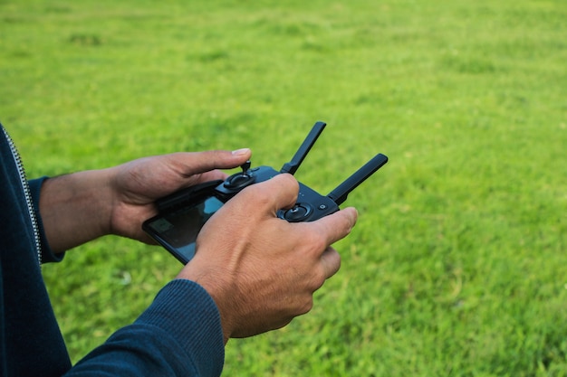 Un uomo controlla il telecomando del drone durante il giorno