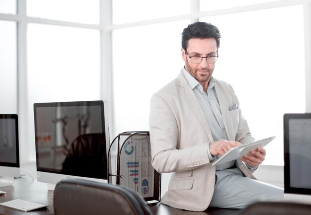 Un uomo d'affari attento utilizza una tavoletta digitale in un ufficio moderno