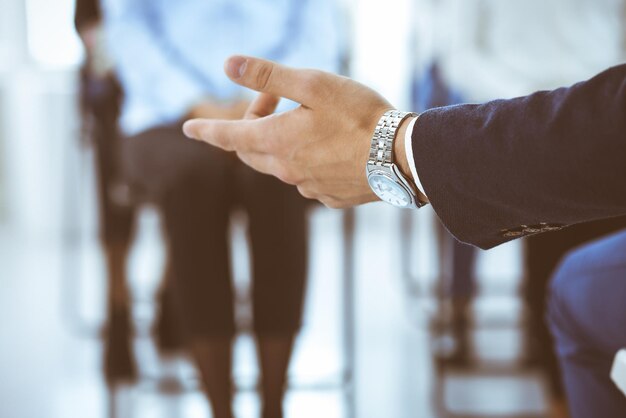 Un uomo d'affari che fa una presentazione a un gruppo di persone in ufficio. Un oratore che tiene un seminario per i suoi colleghi o una formazione aziendale. Lavoro di squadra e concetti di coaching negli affari.