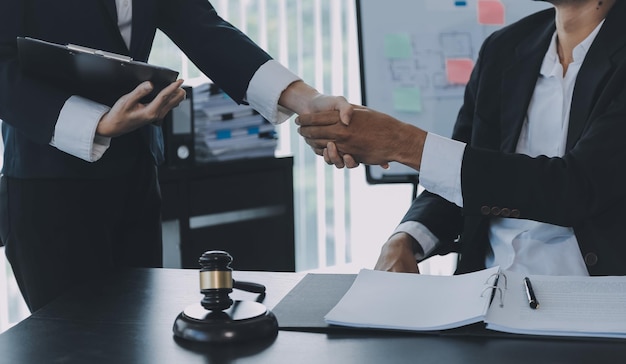Un uomo d'affari che stringe la mano per siglare un accordo con i suoi avvocati o avvocati partner che discutono di un accordo contrattuale