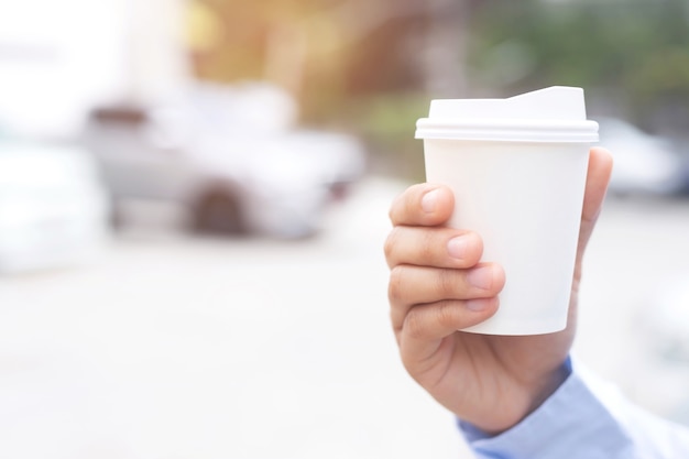 Un uomo d'affari con in mano una tazza di caffè caldo, ha bevuto il caffè prima di guidare.