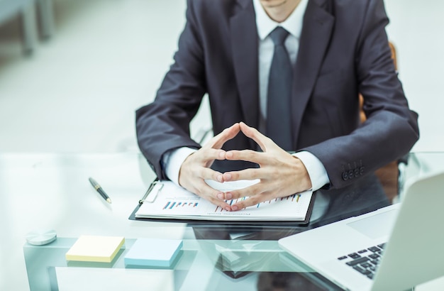 Un uomo d'affari di successo sta valutando la politica finanziaria dell'azienda seduta dietro una scrivania