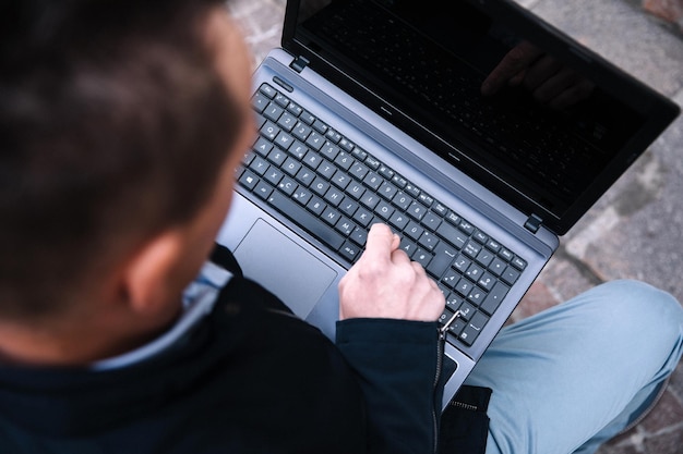 Un uomo d'affari fiducioso con un laptop in città Acquisti online di comunicazioni di visione aziendale