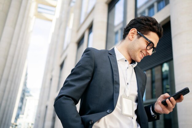 Un uomo d'affari fiducioso utilizzando un telefono Un manager con gli occhiali andare a lavorare in ufficio