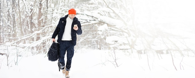 Un uomo d'inverno nella foresta. Un turista con uno zaino attraversa i boschi in inverno. Salita invernale.