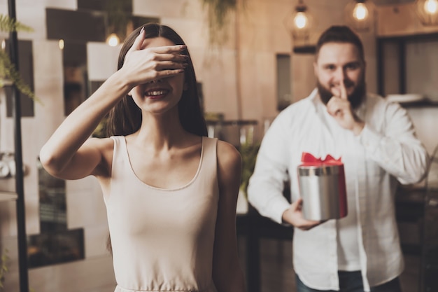 Un uomo dà un regalo ad una ragazza con gli occhi chiusi