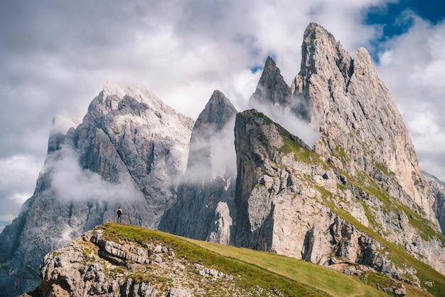 Un uomo di fronte alle epiche cime Furchetta e Sass Rigais nella catena montuosa delle Dolomiti Seceda Alpi Odle