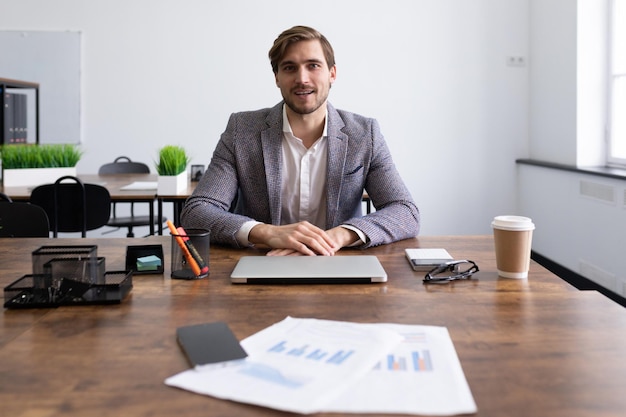 Un uomo di successo durante un colloquio in ufficio parla di se stesso mentre è seduto davanti al