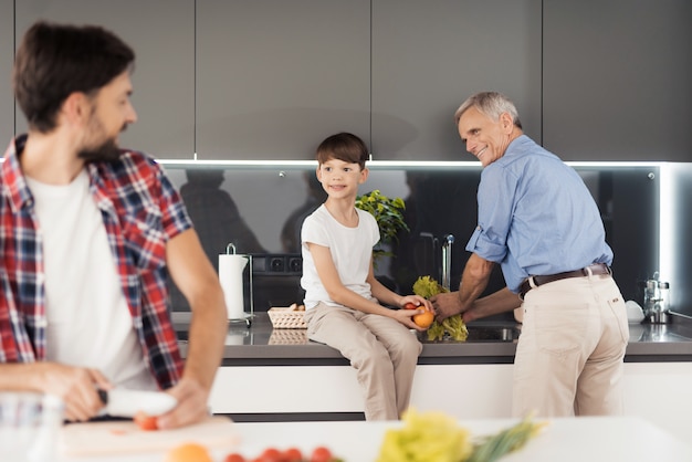 Un uomo è in piedi in cucina e taglia le verdure