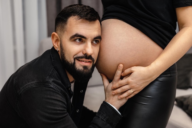 Un uomo è inginocchiato sul pavimento accanto a una donna incinta.