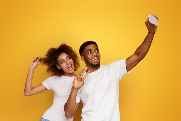 Un uomo e una donna afroamericani felici che si fanno un selfie.