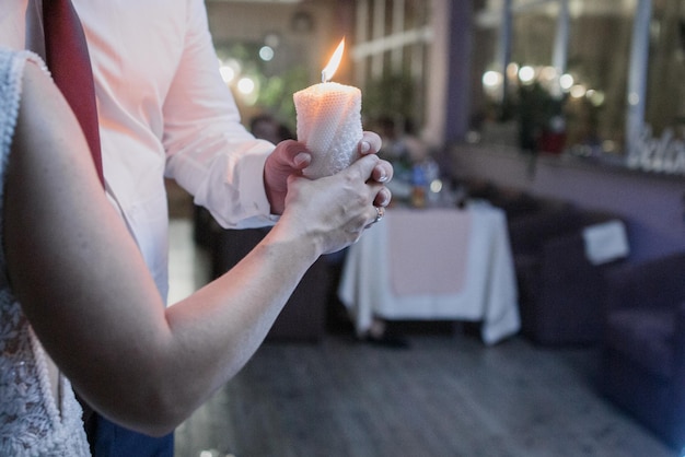 Un uomo e una donna tengono una candela in un ristorante.