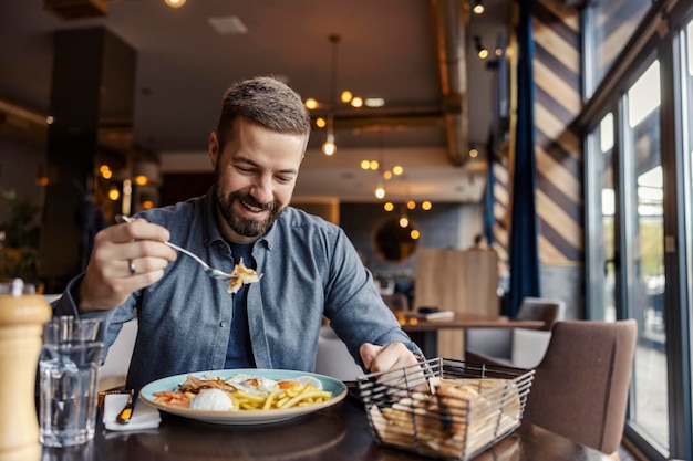 Un uomo felice sta facendo colazione al ristorante