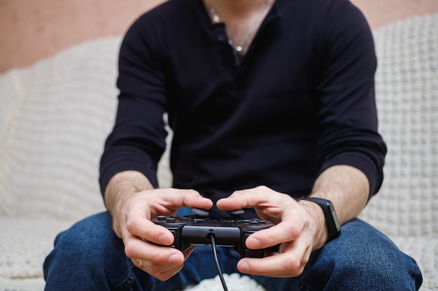 Un uomo gioca ai videogiochi con un joystick in mano