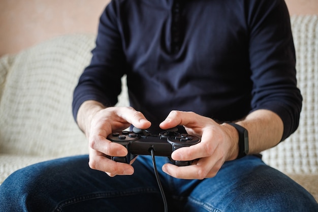 Un uomo gioca ai videogiochi con un joystick in mano