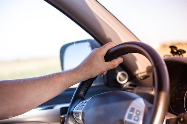 Un uomo guida un'auto e gira il volante