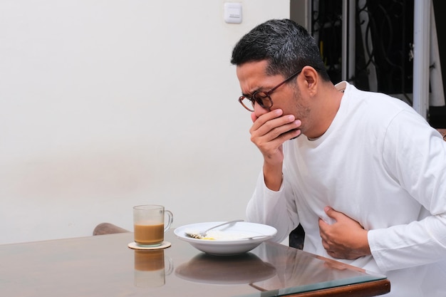 Un uomo ha la nausea quando mangia.