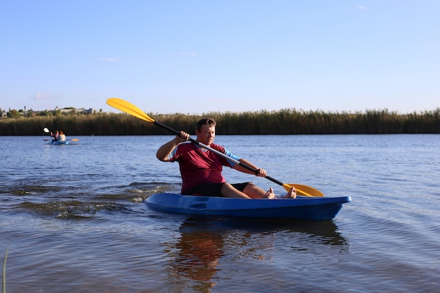 Un uomo in estate galleggiante sul fiume in kayak