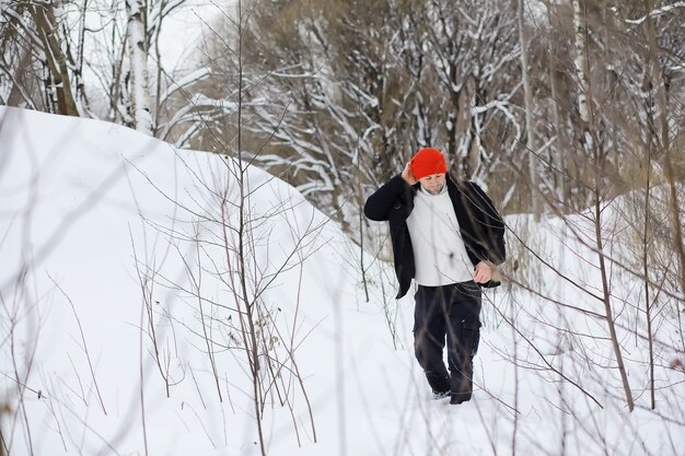 Un uomo in inverno nella foresta. Un turista con uno zaino attraversa i boschi in inverno. Ascesa invernale.