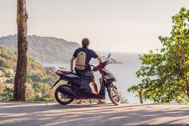 Un uomo in moto contro il mare.