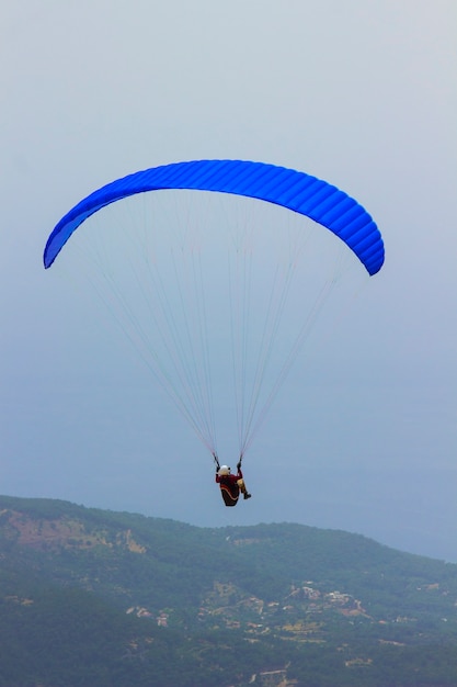 Un uomo in paracadute sta volando sopra le montagne