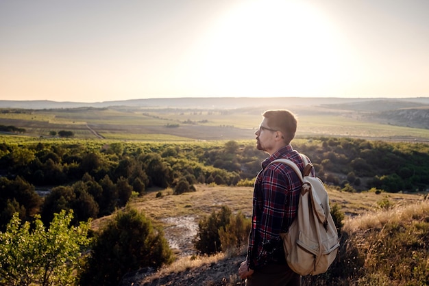 Un uomo in piedi su una montagna mentre il sole tramonta