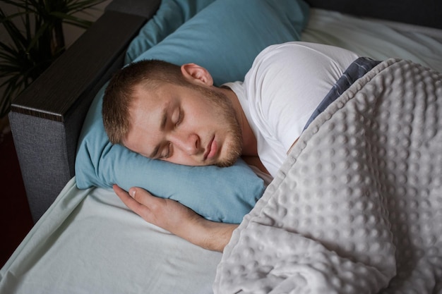 Un uomo in pigiama dorme a letto