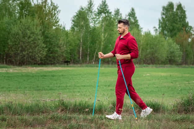 Un uomo in tuta è impegnato nel nordic walking