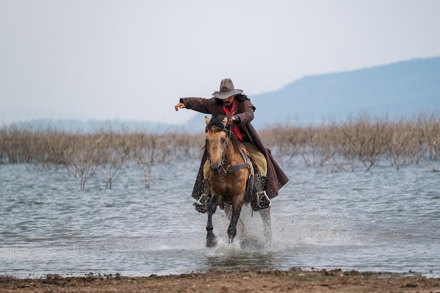 Un uomo in un vestito da cowboy con il suo cavallo