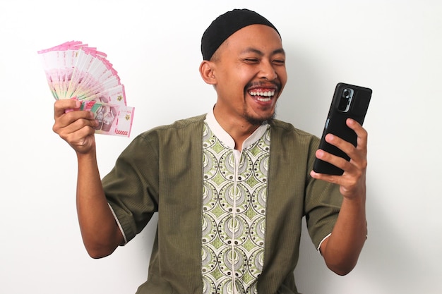 Un uomo indonesiano celebra le vincite con telefono e contanti