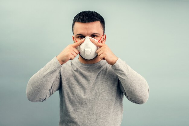 Un uomo indossa una maschera protettiva. Protezione respiratoria dal coronavirus. Dispositivi di protezione individuale per una pandemia di un'infezione virale. Covid19.