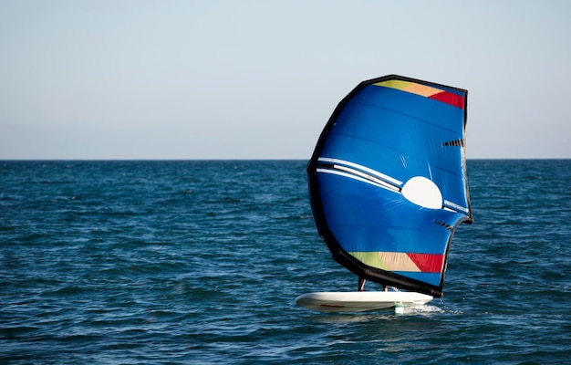 Un uomo lascia la spiaggia di El Palo a Malaga in sella a un paddle board con un aliscafo