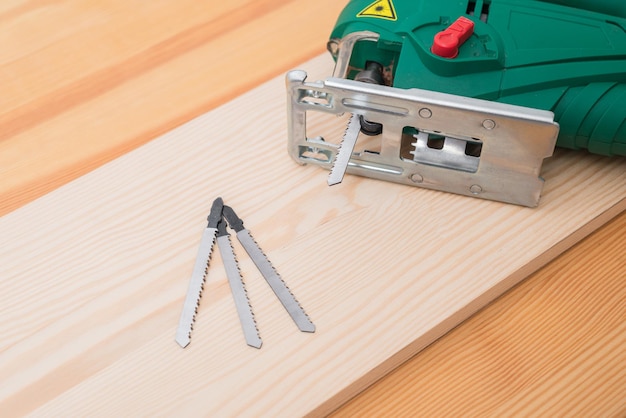 Un uomo lavora con un puzzle elettrico per legno su un tavolo di legno con e senza guanti e misura con un metro a nastro
