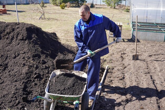 Un uomo lavora in un orto all'inizio della primavera