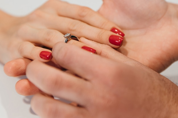 Un uomo mette delicatamente un anello al dito della sua amata donna dopo una proposta di matrimonio. Foto di alta qualità