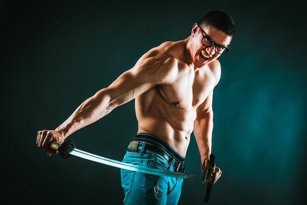 Un uomo muscoloso perfetto sta eseguendo esercizi con la spada katana.