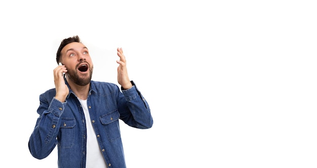 Un uomo parla al telefono gesticolando con le mani a bocca aperta un sorriso e gli occhi sbarrati dentro