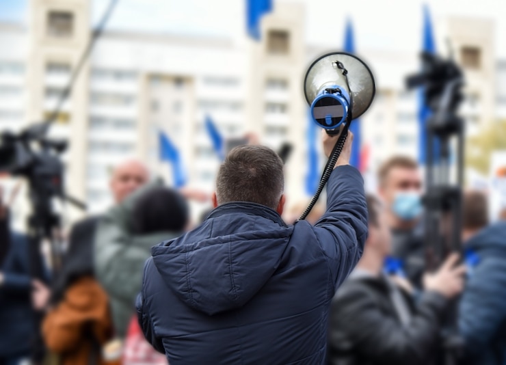 Foto un uomo parla attraverso un altoparlante durante una manifestazione.