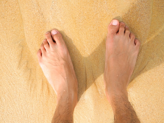 Un uomo piedi, gamba sulla sabbia nella bellissima spiaggia, Day-Off Concept