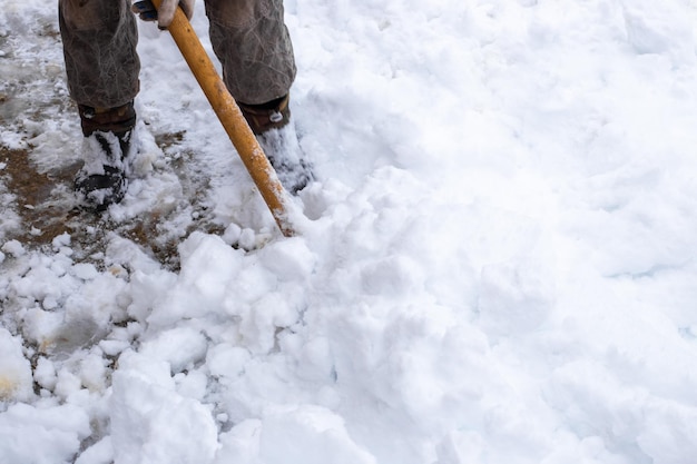 Un uomo rimuove la neve con una pala in una giornata invernale dopo una forte nevicata