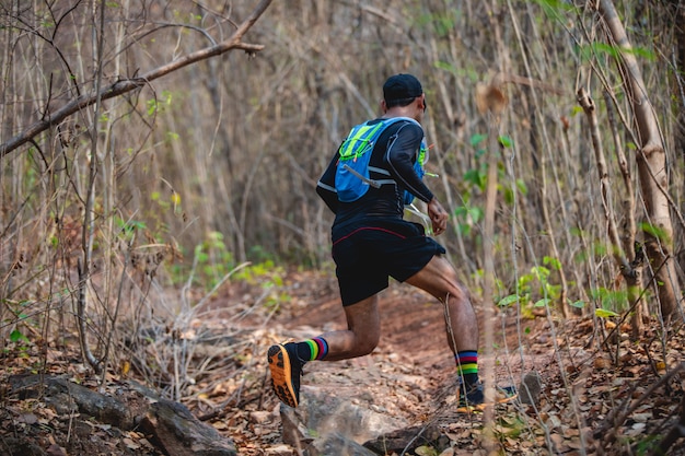 Un uomo Runner of Trail. e i piedi dell&#39;atleta che indossano scarpe sportive per il trail running nella foresta