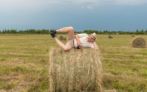 Un uomo sdraiato su una balla di fieno in un campo