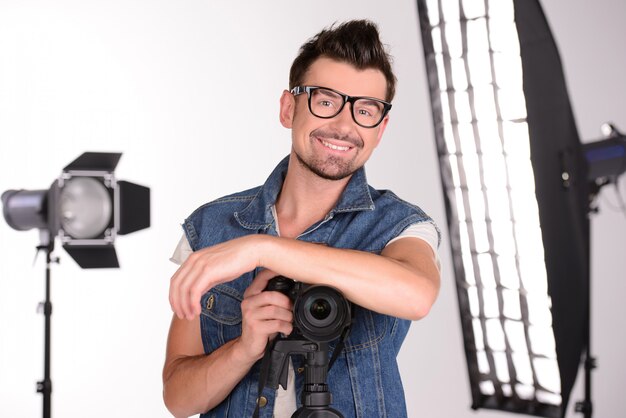 Un uomo si alza e sorride in studio per un servizio fotografico.