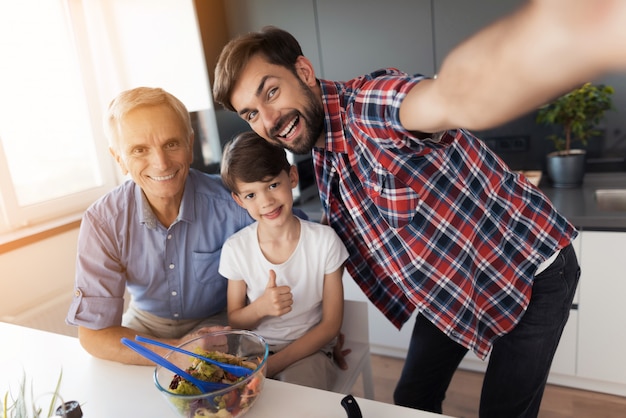 Un uomo si è fotografato, suo padre e suo figlio anziani