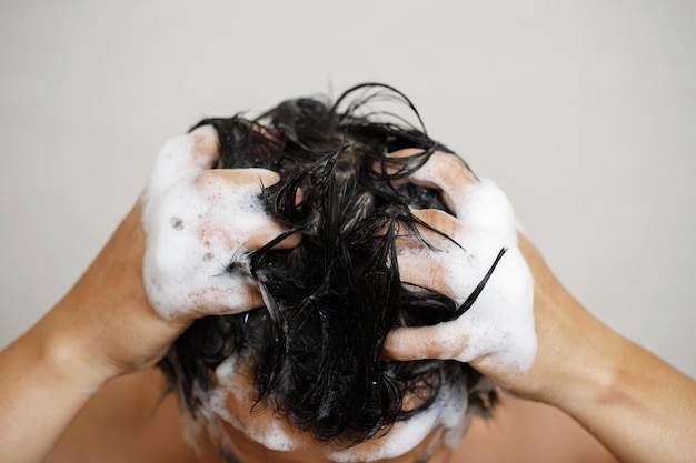 Un uomo si lava i capelli con lo shampoo