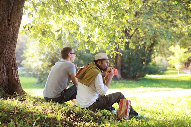 Un uomo si nasconde all'ombra degli alberi in una giornata calda. Pausa pranzo. Riposa a metà della giornata lavorativa.