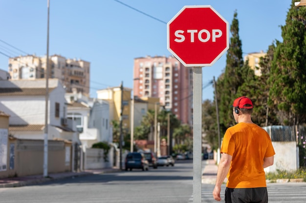 Un uomo si trova a un segnale di stop in città