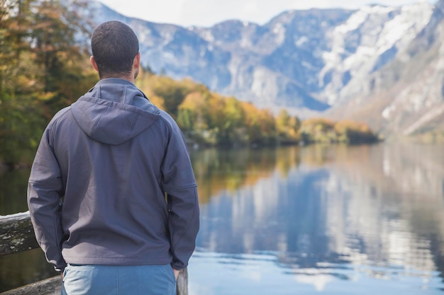 Un uomo si trova vicino al lago di Bohinj in Slovenia con la schiena girata