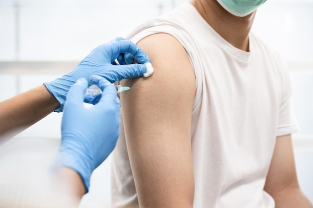 Un uomo si vaccina in ospedale contro il Covid-19. (seleziona focus)