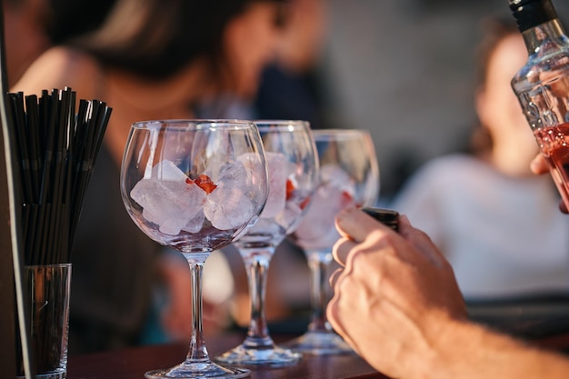 Un uomo siede in un bar con bicchieri di vino e una bottiglia di vino.